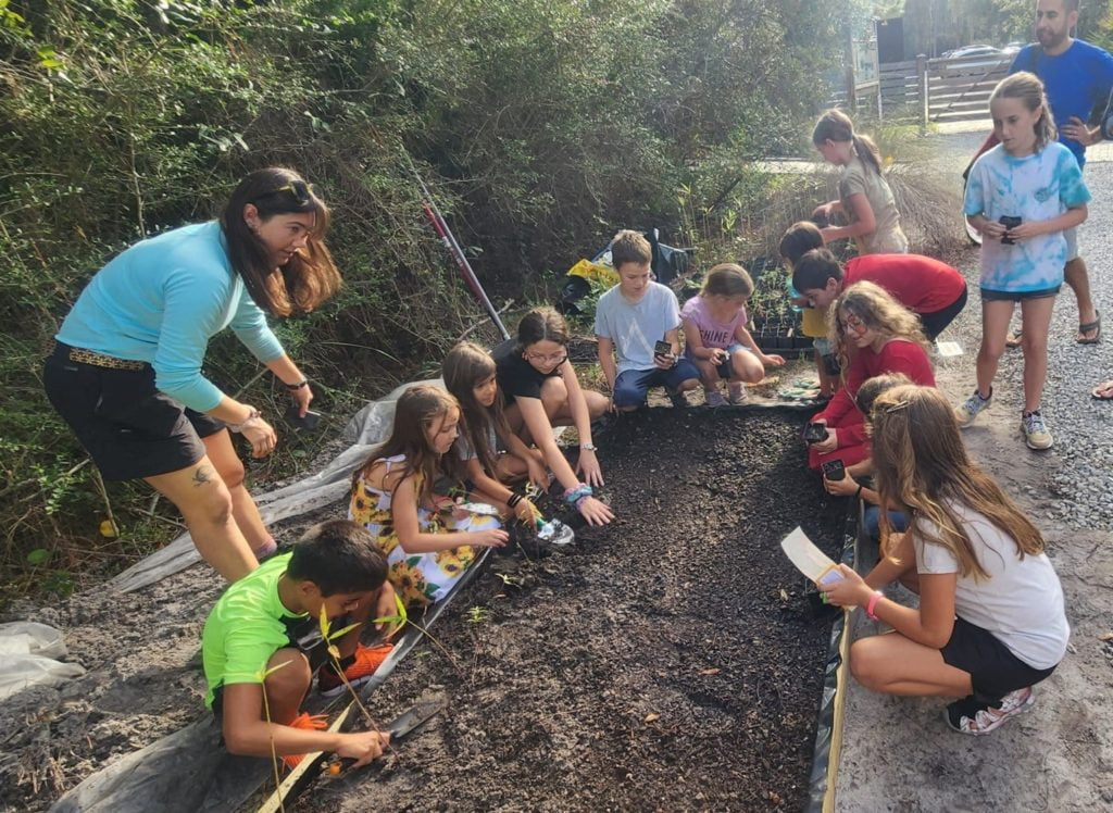 Children planting native swamp milkweed in ANERR’s garden. Plants were donated by Scott Davis from the Monarch Milkweed Initiative.
