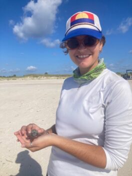 Summer 2023 stewardship intern, Wallace Walker, holds a loggerhead sea turtle encountered during a nest evaluation in preparation for release.